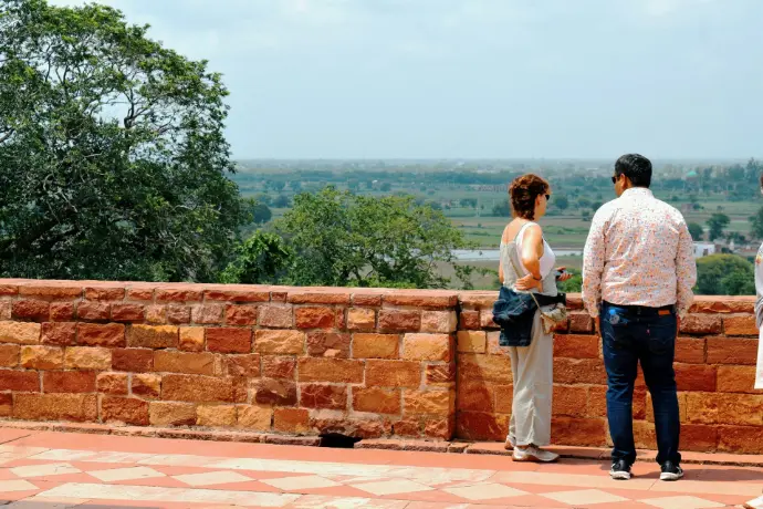 a man and a woman standing on top of a brick wall